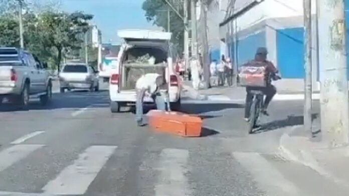 Motorista do carro precisou de ajuda de outras pessoas para recolocar o caixão